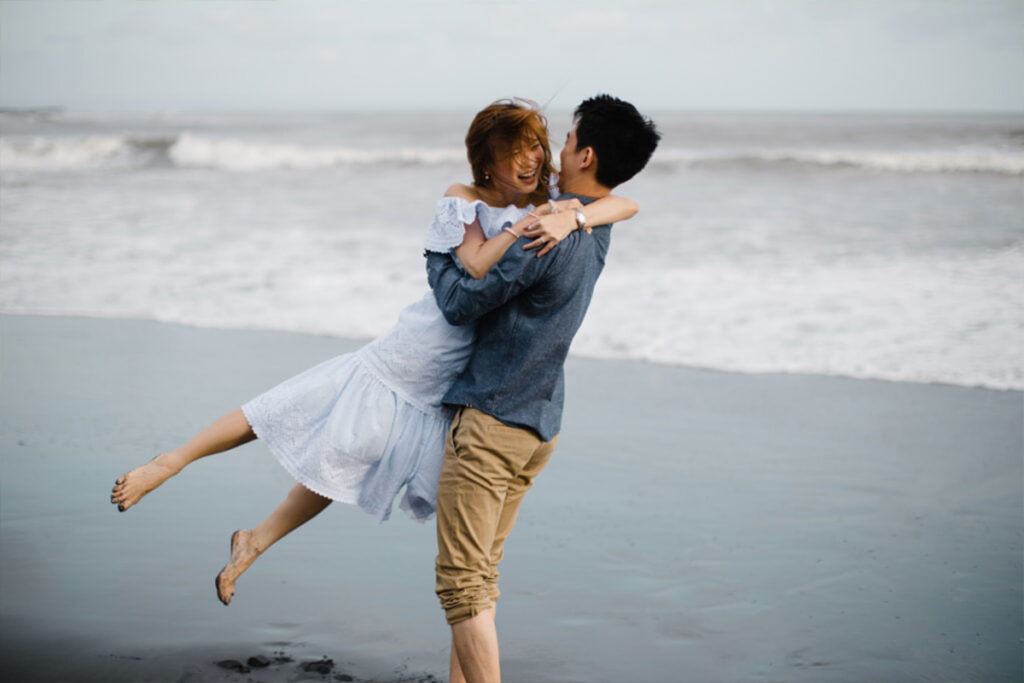 Back view of couple sitting and hugging on the beach | Couples, Love couple  photo, Couple beach